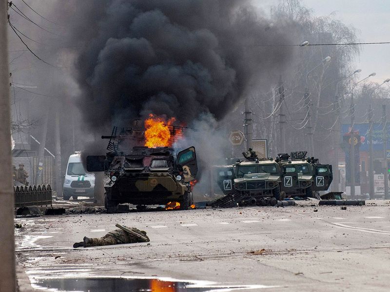 A Russian armoured personnel carrier burns amid damaged and abandoned light utility vehicles after fighting in Kharkiv, Ukraine. 