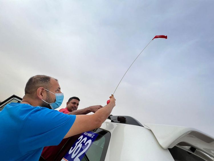 Satish and Arjun setting up the flag on top of their car. The flag serves as a warning to the vehicle behind, especially while crossing the dunes. 