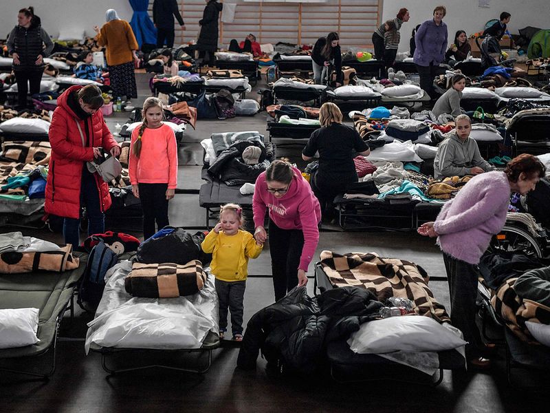 A child reacts as refugees rest in a temporary shelter at a gym of a primary school in Przemysl, near the Polish-Ukrainian border on March 12, 2022.  