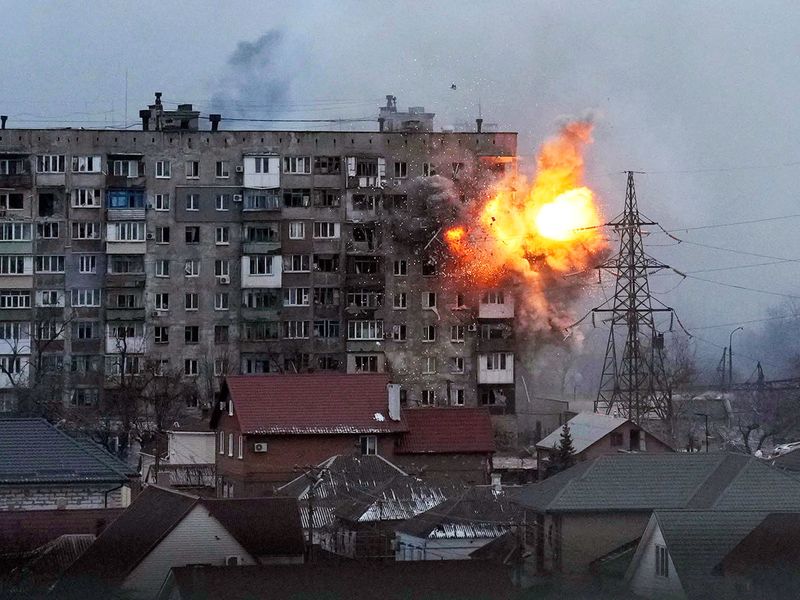An explosion is seen in an apartment building after Russian's army tank fires in Mariupol. 
