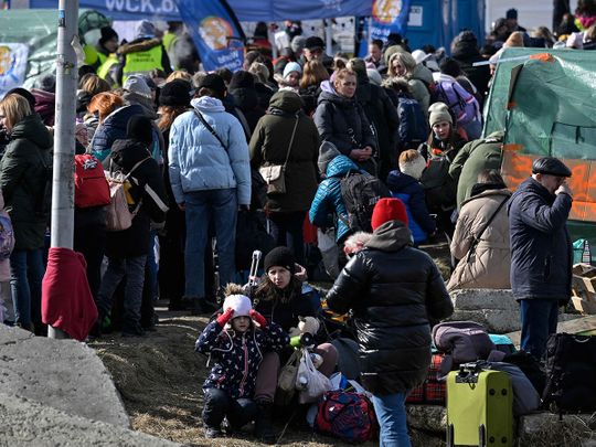 Refugees wait for further transport at the Medyka border crossing at the Polish-Ukrainian border, southeastern Poland on March 12, 2022.  
