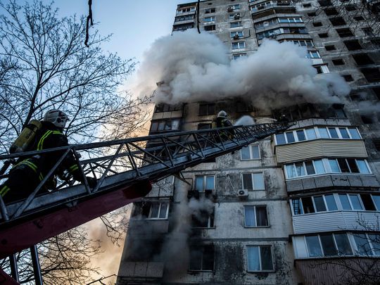 Firefighters try to extinguish a fire at a high-rise apartment building after the predawn missile attack in Kyiv. 