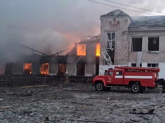 Firemen work to extinguish a fire at an educational institution hit by shelling in the town of Merefa in the Kharkiv region.  