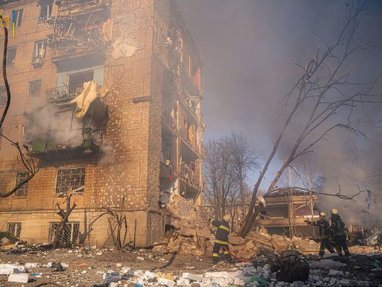 Rescuers work next to a residential building damaged by shelling, in Kyiv, Ukraine, on March 18, 2022.   