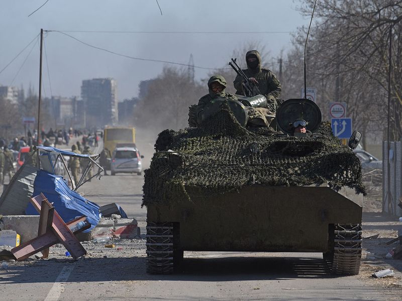 Service members of pro-Russian troops in uniforms without insignia drive an armoured vehicle during Ukraine-Russia conflict in the besieged southern port city of Mariupol, on March 19, 2022. 