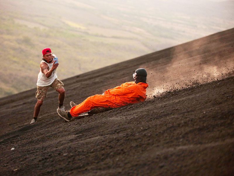 A tourist slides down the slopes of the Cerro Negro volcano.