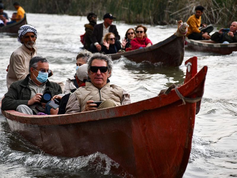 Spanish visitors of the Marshes of Jabayesh in southern Iraq ride boats as they tour the area. 