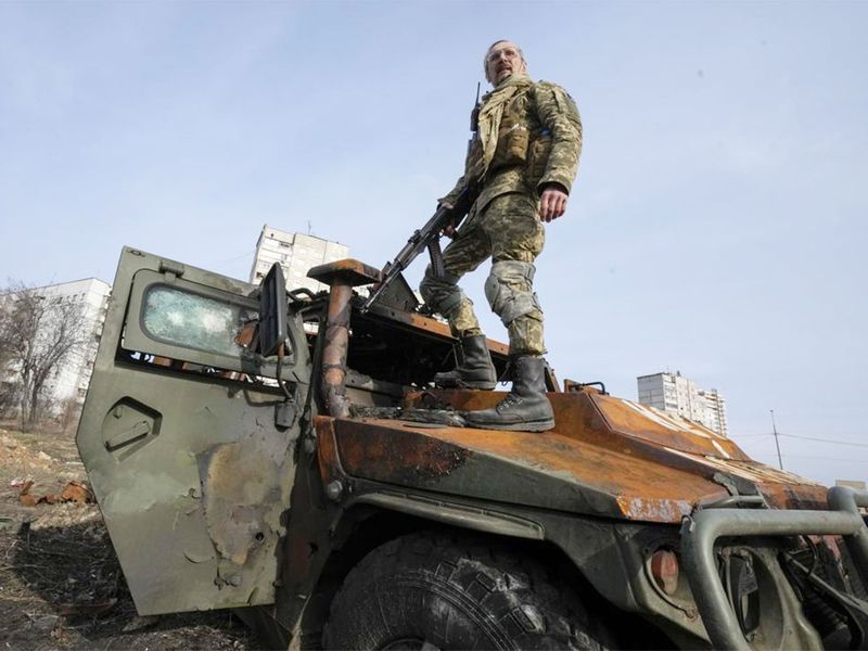 A Ukrainian soldier stands a top a destroyed Russian APC after recent battle in Kharkiv, Ukraine. 