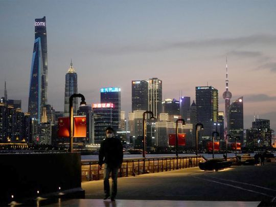 A man walks in front of Lujiazui financial district, seen across the Huangpu river at dusk, amid the lockdown in Pudong area in Shanghai. R
