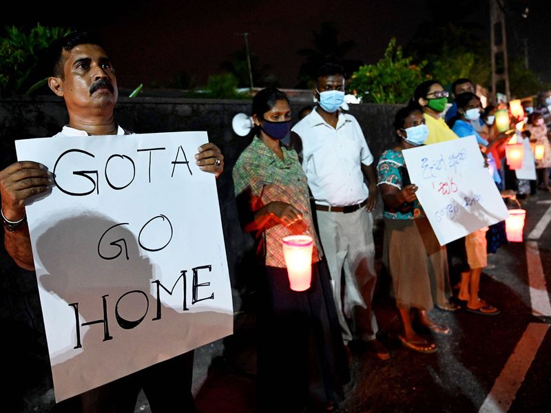 People take part in a demonstration to denounce the shortage of cooking gas, kerosene oil and other essential commodities on the outskirts of Colombo.
