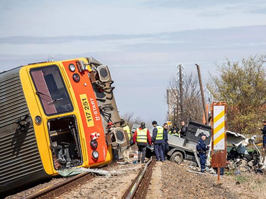 Police officers and firemen inspect the scene after a passenger train travelling on the Szentes - Hodmezovasarhely line derailed and careened into a ditch 60 metres from the site of the impact in Mindszent, Hungary, on April 15, 2022.  