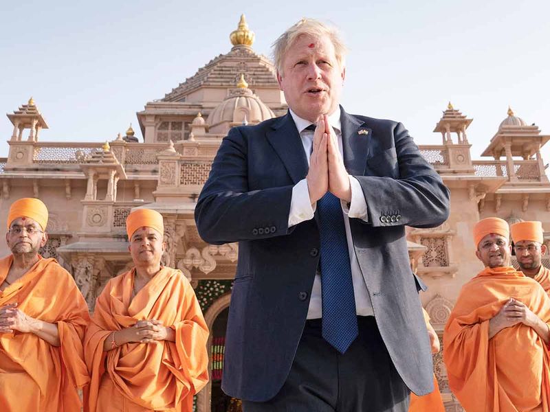 British Prime Minister Boris Johnson walks with sadhus, Hindu holymen, as he visits the Swaminarayan Akshardham temple in Gandhinagar, Ahmedabad. 