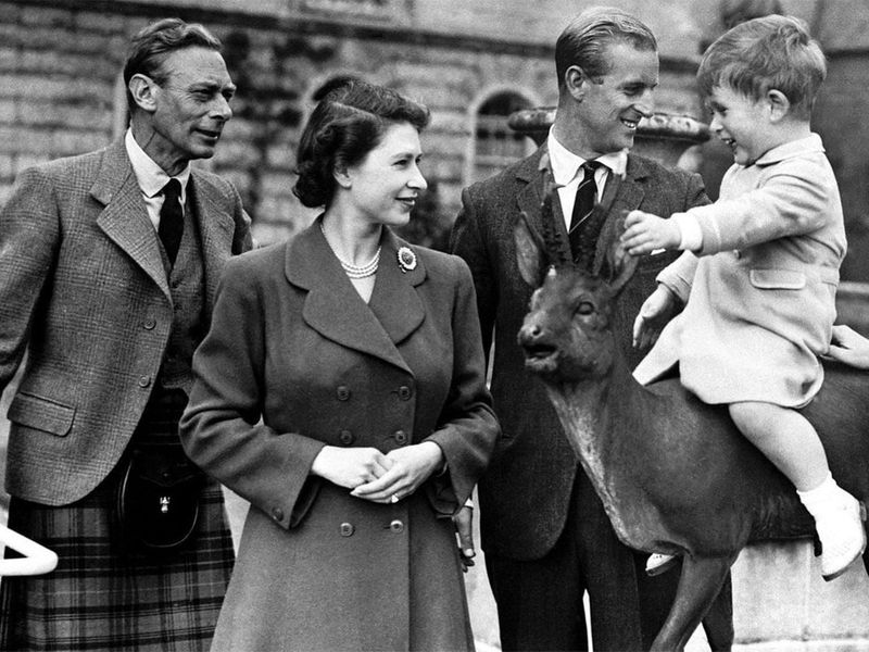 To mark #FathersDay we are sharing this photograph of The Queen with her father, King George VI, and Prince Philip watching a young Prince Charles sitting on a statue at Balmoral in 1951.