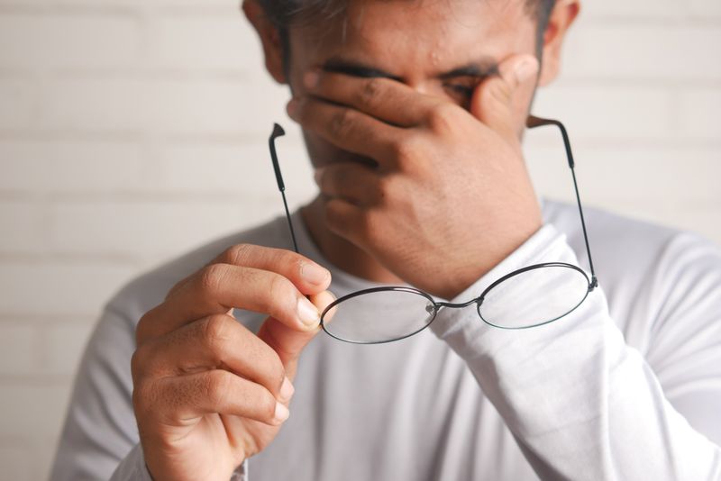 Man rubbing eyes headache 