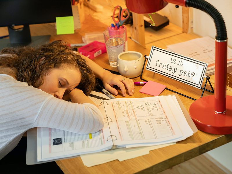 Woman tired sleep at desk work short sleep 