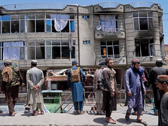 Taliban fighters stand guard at the site of an explosion in front of a Sikh temple in Kabul, on Saturday, June 18, 2022. 