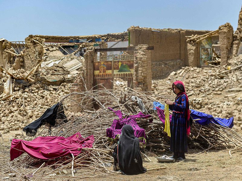 Afghan people keep their clothes to dry on dried out shrubs near the ruins of houses damaged by an earthquake in Bernal district, Paktika province.