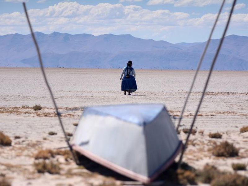Cristina Mamani walks near an unused boat in Lake Poopo, Bolivia's second largest lake. 