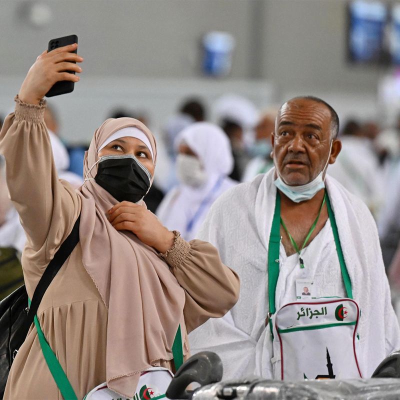 A pilgrim uses her mobile phone to take a picture.