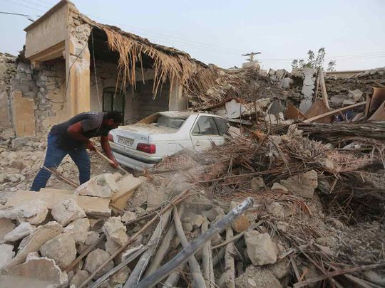 A man cleans up the rubble after an earthquake at Sayeh Khosh village in Hormozgan province, some 1,000 kilometers south of Tehran, Iran,on Saturday, July 2, 2022.