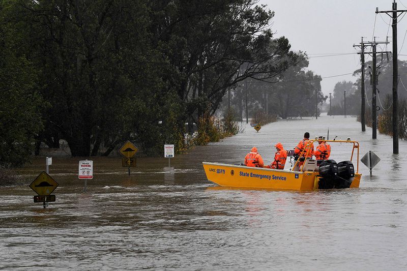 A New South Wales State Emergency Service (SES) crew is seen in a rescue boat as roads are submerged under floodwater from the swollen Hawkesbury River in Windsor, northwest of Sydney, Monday, July 4, 2022. 