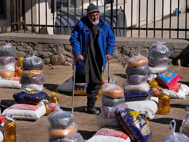 A man stands among piles of humanitarian food supplies in Kabul, Afghanistan. 