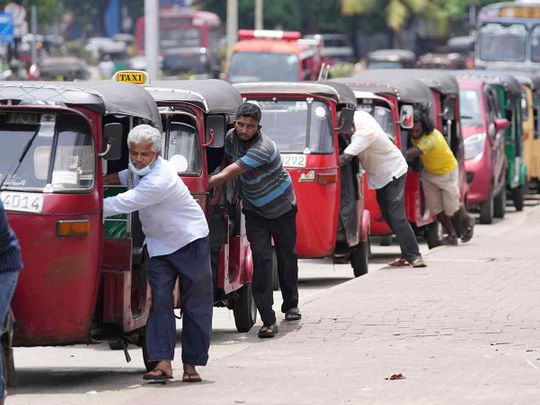 Auto rickshaw drivers line up to buy gas near a fuel station in Colombo, Sri Lanka.