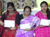 Shila Rani Das and her daughters pose with their certificates.