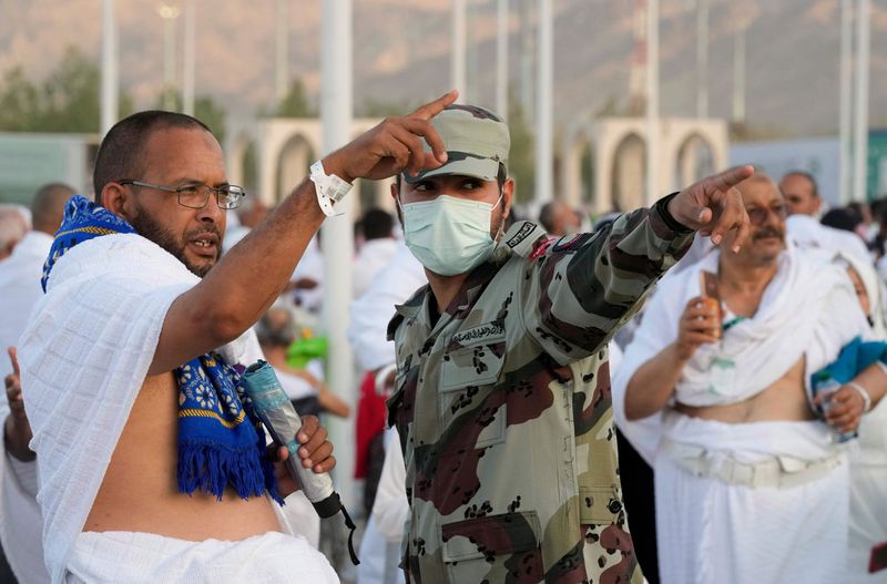 A Saudi policeman directs a Muslim pilgrim to the way of the rocky hill known as the Mountain of Mercy, on the Plain of Arafat, during the annual hajj pilgrimage, near the holy city of Mecca, Saudi Arabia, Friday, July 8, 2022. One million pilgrims from across the globe amassed on Thursday in the holy city of Mecca in Saudi Arabia to perform the initial rites of the hajj, marking the largest Islamic pilgrimage since the coronavirus pandemic upended the annual event — a key pillar of Islam.