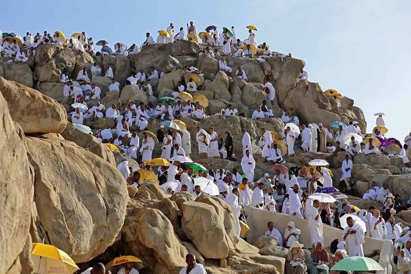 Muslim pilgrims gather atop Mount Arafat, also known as Jabal al-Rahma (Mount of Mercy), southeast of the holy city of Mecca, during the climax of the Hajj pilgrimage, early on July 8, 2022. (Photo by Christina ASSI / AFP)