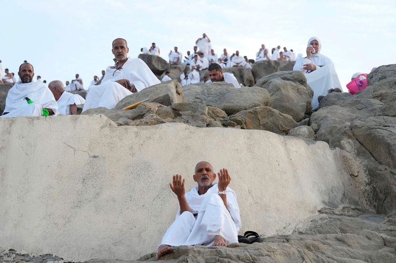 Muslim pilgrims pray on top of  the Mountain of Mercy, on the Plain of Arafat, during the annual hajj pilgrimage, near the holy city of Mecca, Saudi Arabia, Friday, July 8, 2022.