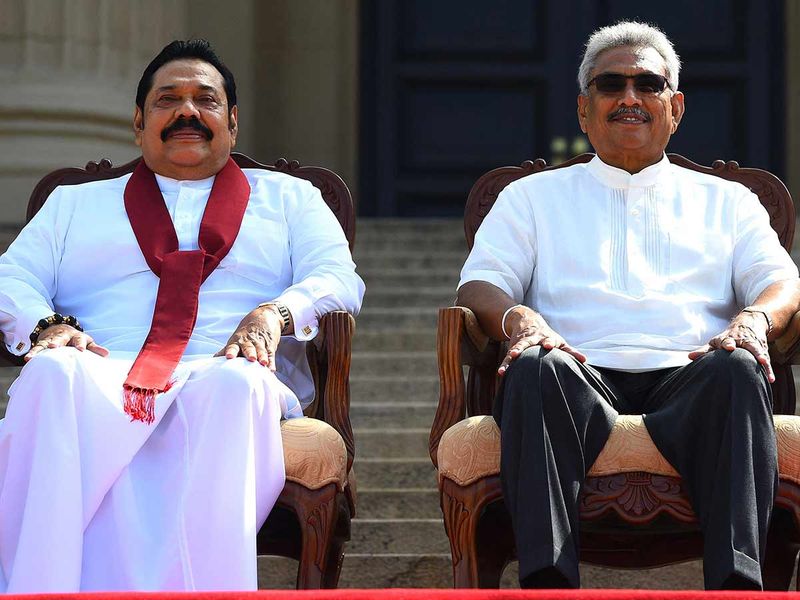  In this file photo taken on November 22, 2019, Sri Lanka's new President Gotabaya Rajapaksa (R) and his Prime Minister brother Mahinda Rajapaksa, pose for a group photograph after the ministerial swearing-in ceremony in Colombo.