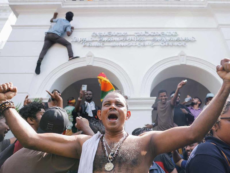 Demonstrators celebrate after they entered into Sri Lankan Prime Minister Ranil Wickremasinghe's office during a protest demanding for his resignation, after President Gotabaya Rajapaksa fled, amid the country's economic crisis, in Colombo, Sri Lanka, July 13, 2022