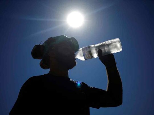 A worker drinks water on a road site in Aigrefeuille-sur-Maine near Nantes, as a heatwave hits France. 
