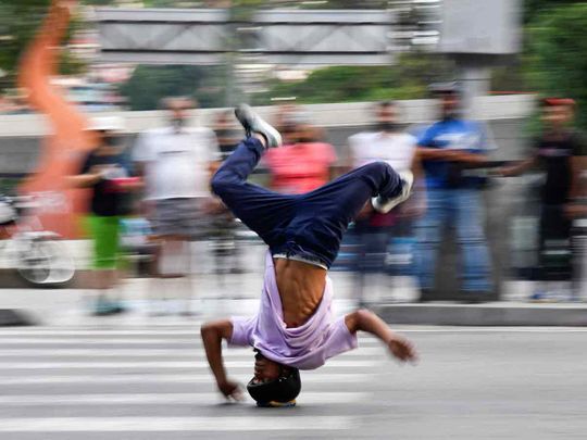 Kenyer Mendez slides down a street headfirst at a traffic light, in Caracas. 