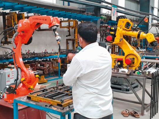A technician works on a robot in Nigel's firm