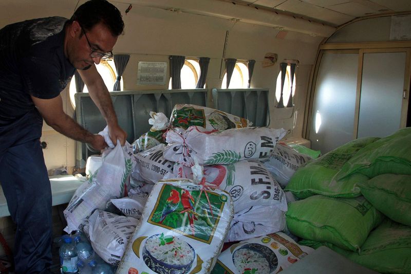 A worker loads foodstuff into a helicopter for distribution among displaced people in flood-hit areas, in Sadu Sharif, Swat Valley, Pakistan, Monday, Aug. 29, 2022. International aid was reaching Pakistan on Monday, as the military and volunteers desperately tried to evacuate many thousands stranded by widespread flooding driven by 