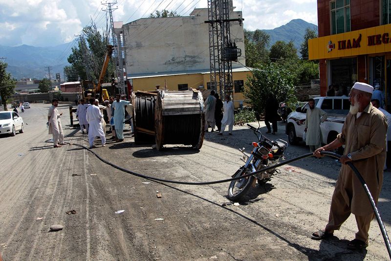 Government workers repair electricity cables to restore services damaged by flooding, in Kanju, Swat Valley, Pakistan, Monday, Aug. 29, 2022. International aid was reaching Pakistan on Monday, as the military and volunteers desperately tried to evacuate many thousands stranded by widespread flooding driven by 
