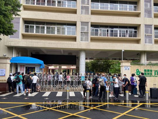Volunteers arrive to a primary school repurposed for virus control efforts in Futian district, following the COVID-19)outbreak in Shenzhen, Guangdong province, on August 31, 2022. 