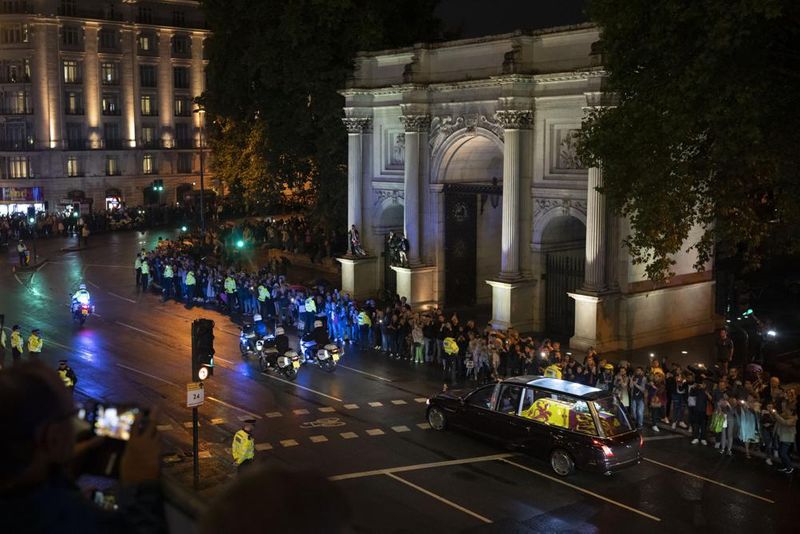 The hearse carrying the coffin of Queen Elizabeth II arrives at Buckingham Palace, London, Tuesday, Sept. 13, 2022, from where it will rest overnight in the Bow Room. 