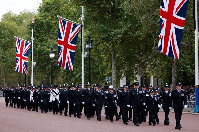 Police officers march up the Mall in central London Monday Sept. 19, 2022. The Queen, who died aged 96 on Sept. 8, will be buried at Windsor alongside her late husband, Prince Philip, who died last year. 