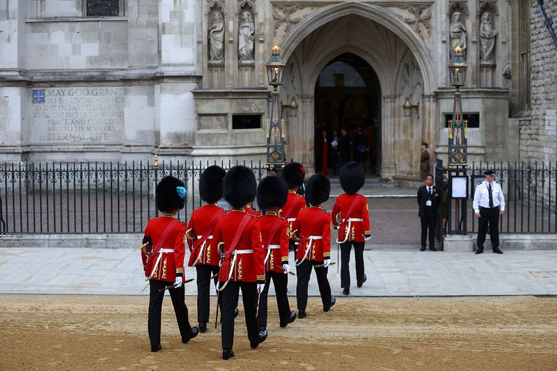 Soldiers in ceremonial uniform walk into Westminster Abbey, on the day of the state funeral of Queen Elizabeth, in London.