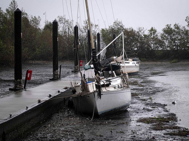 Sail boats lie on the bottom of Charlotte Harbor during a tide retreat as the eye of Hurricane Ian passes by in Punta Gorda, Florida on September 28, 2022. 