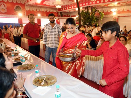 Bollywood actress Kajol with her son Yug Devgn serving Bhog at Durga Puja festival celebration, in Mumbai on Sunday. 