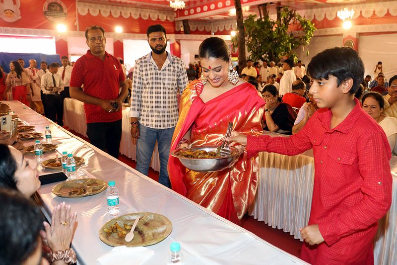 Bollywood actress Kajol with her son Yug Devgn serving Bhog at Durga Puja festival celebration, in Mumbai on Sunday
