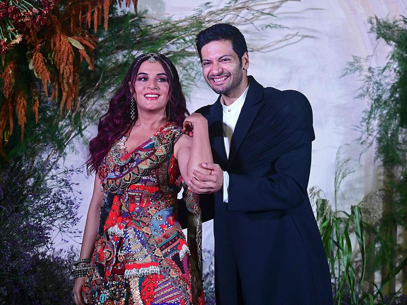 Bollywood actors Richa Chadha (L) and Ali Fazal pose during their wedding reception party in Mumbai on October 4, 2022. (Photo by Sujit JAISWAL / AFP)