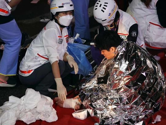 A man receives medical help from rescue team members at the scene where dozens of people were injured in a stampede during a Halloween festival in Seoul, South Korea, October 29, 2022. 