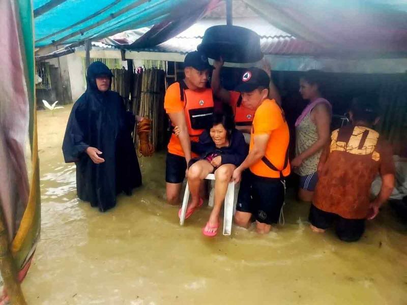 Philippine Coast Guard (PCG) rescuers lift an elderly woman following flooding due to Tropical Storm Nalgae, in Hilongos, Leyte, Philippines. 