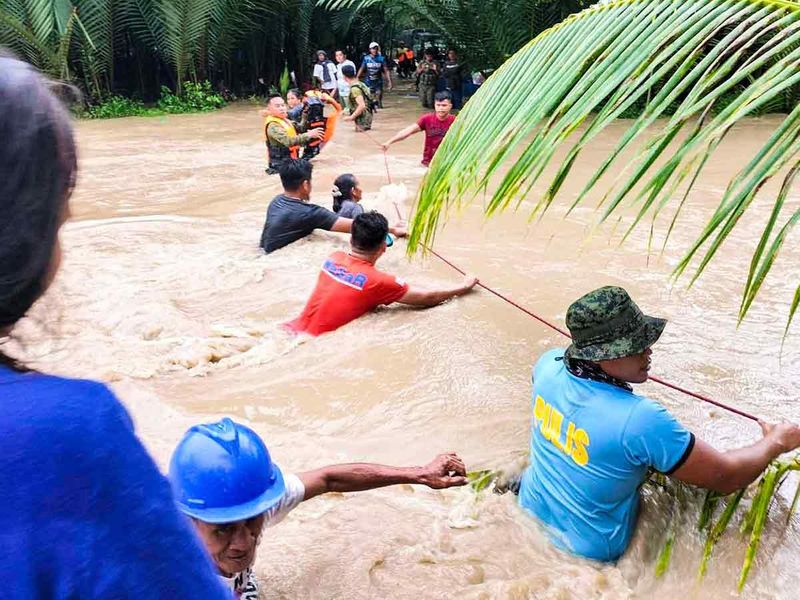 Rescuers help residents evacuate in Kalamansig, Sultan Kudarat, due to heavy rains resulting in floodings brought by Tropical Storm Nalgae. 
