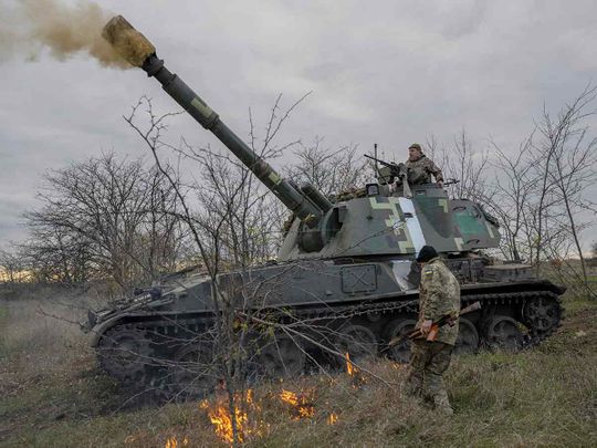 Ukrainian artillery unit members fire towards Kherson